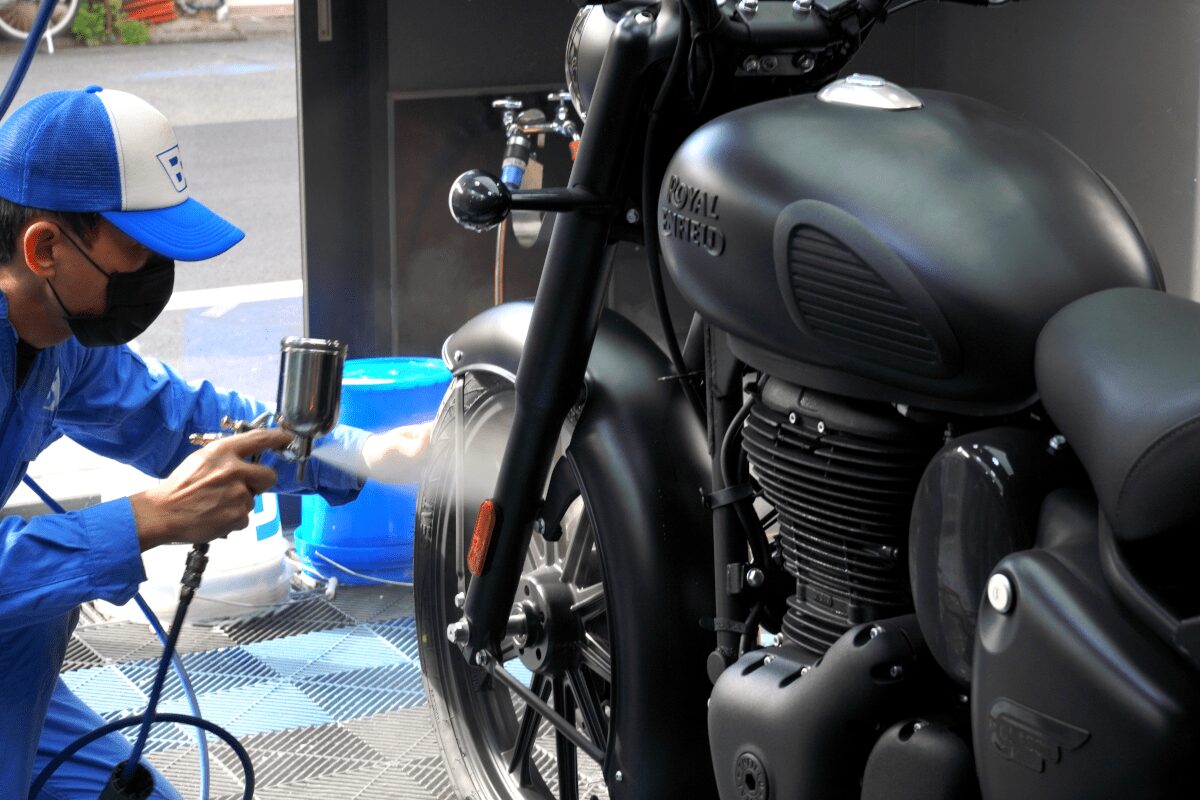 BB商会バイク洗車センターの洗車作業の様子　ROYAL ENFIELD CLASSIC350にガラスコーティング剤を塗布している状態　フロントタイヤ部