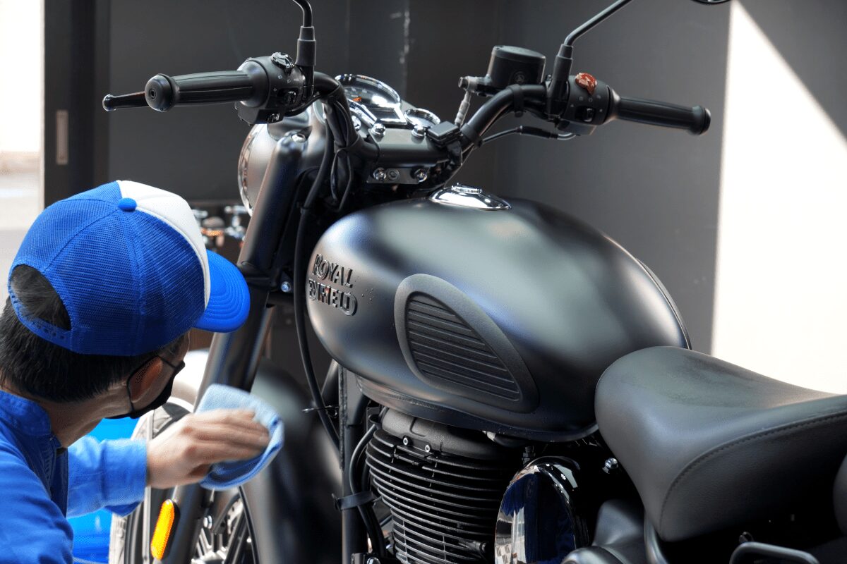 BB商会バイク洗車センターの洗車作業の様子　ROYAL ENFIELD CLASSIC350にガラスコーティング剤を塗布している状態　車体全体にコーティング剤を塗布