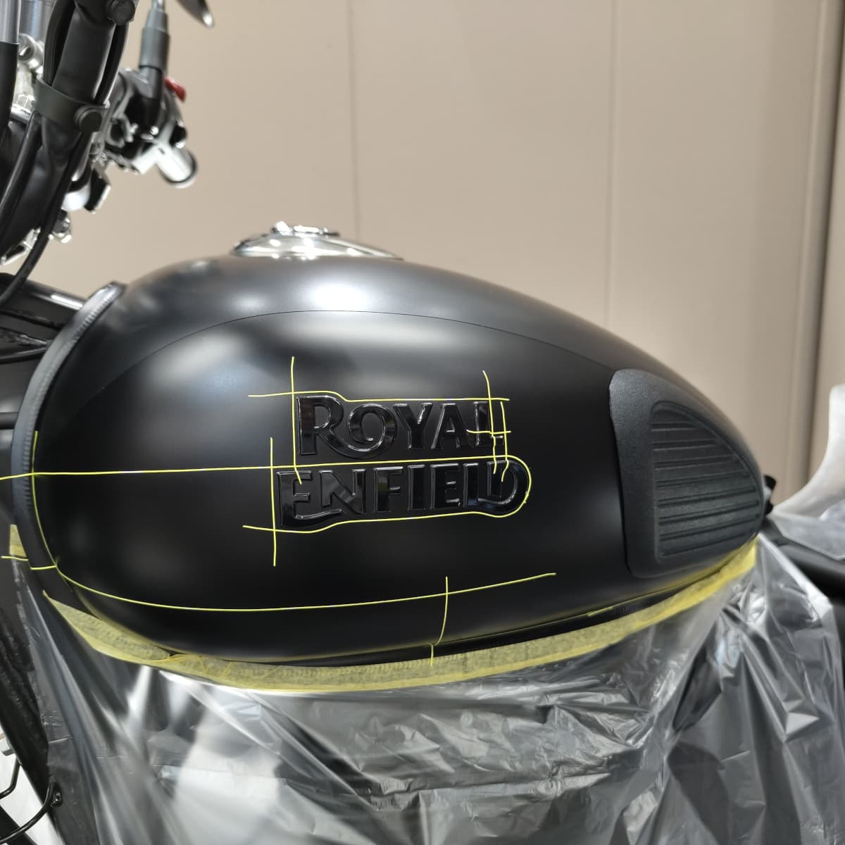 ROYAL ENFIELD CLASSIC 350のタンクのPPF施工（ペイントプロテクションフィルム施工）のためにマスキングテープで目印をつけている様子